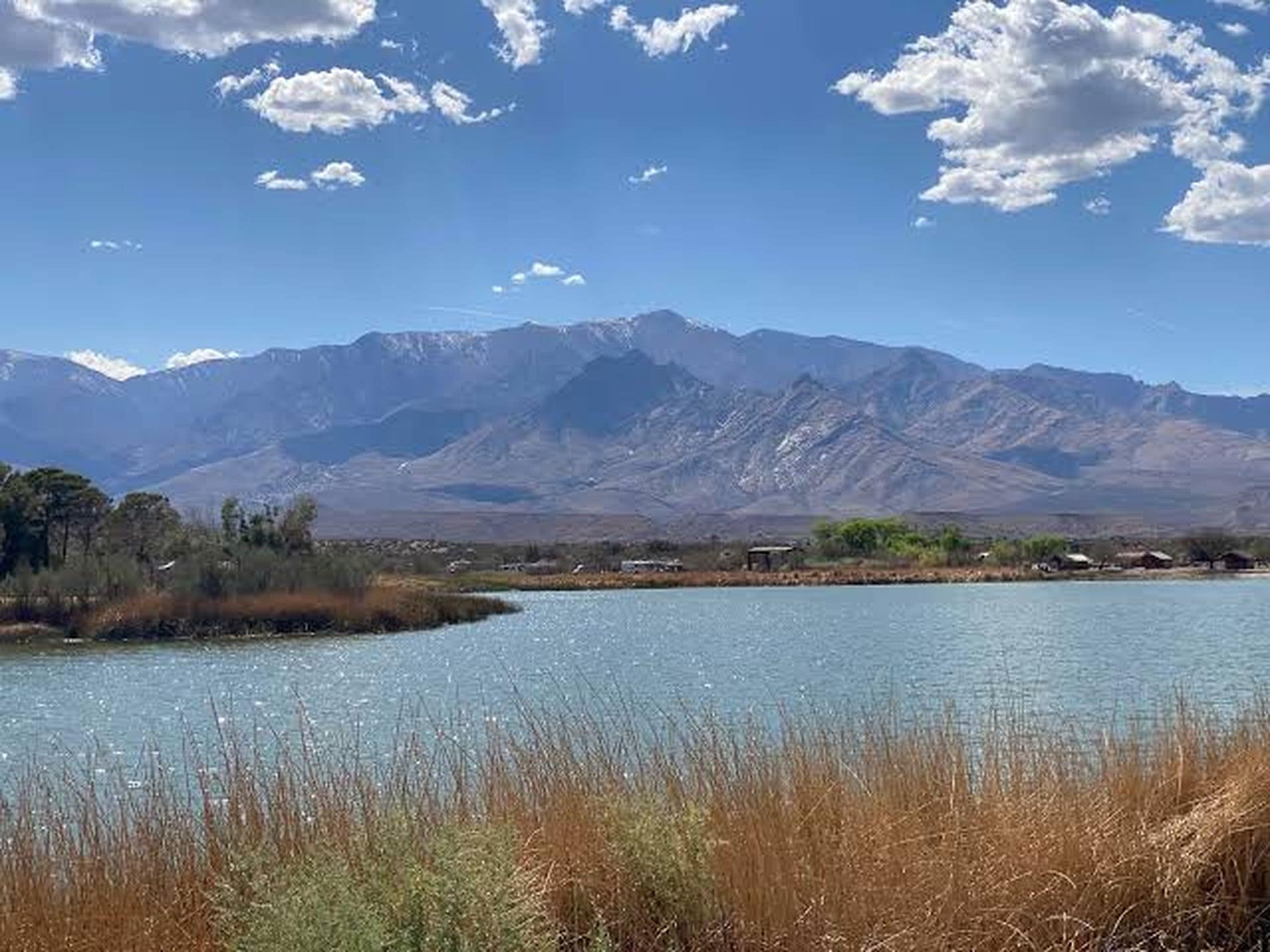 Un lac avec des montagnes en arrière-plan et un ciel dégagé.