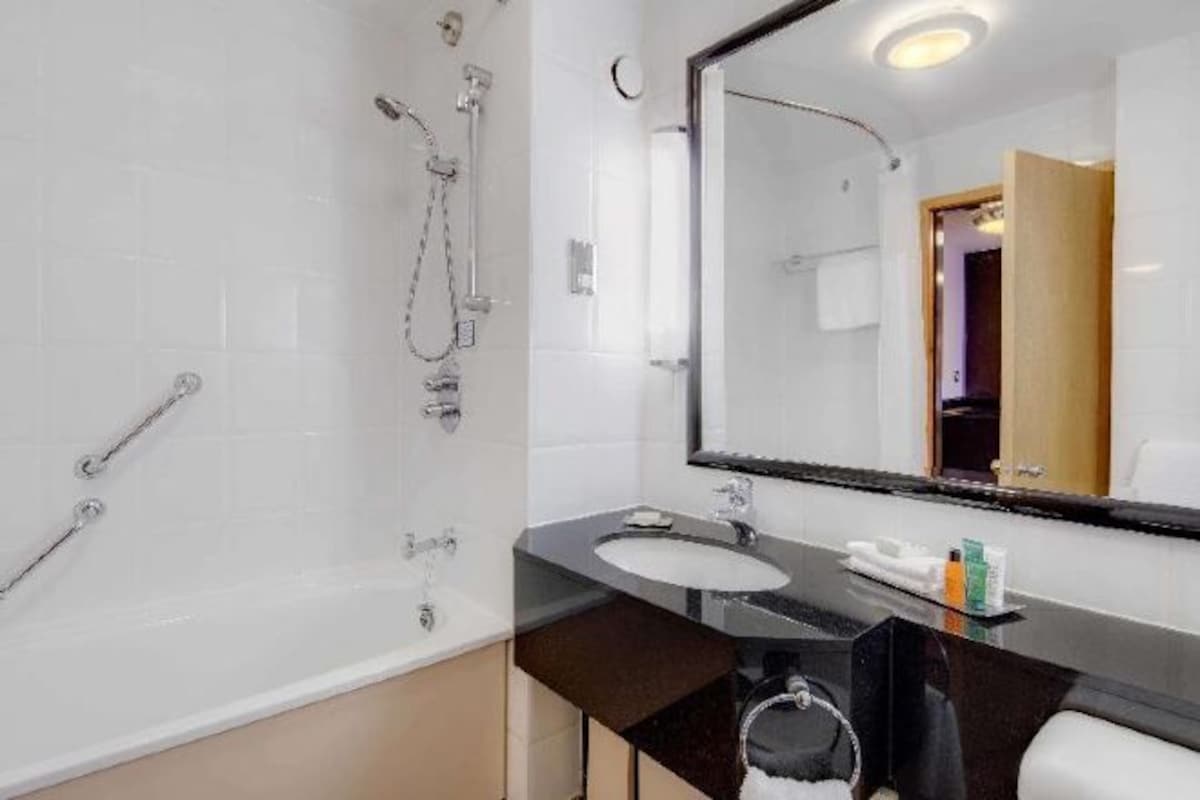 A modern bathroom with a bathtub, a sink, and a shower.