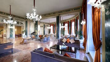 A spacious lobby with high ceilings, chandeliers, and comfortable seating areas.