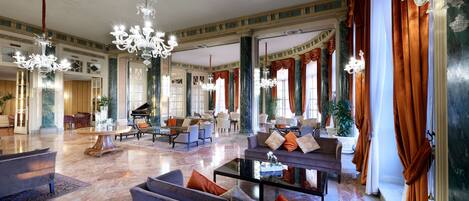 A spacious lobby with high ceilings, chandeliers, and comfortable seating areas.