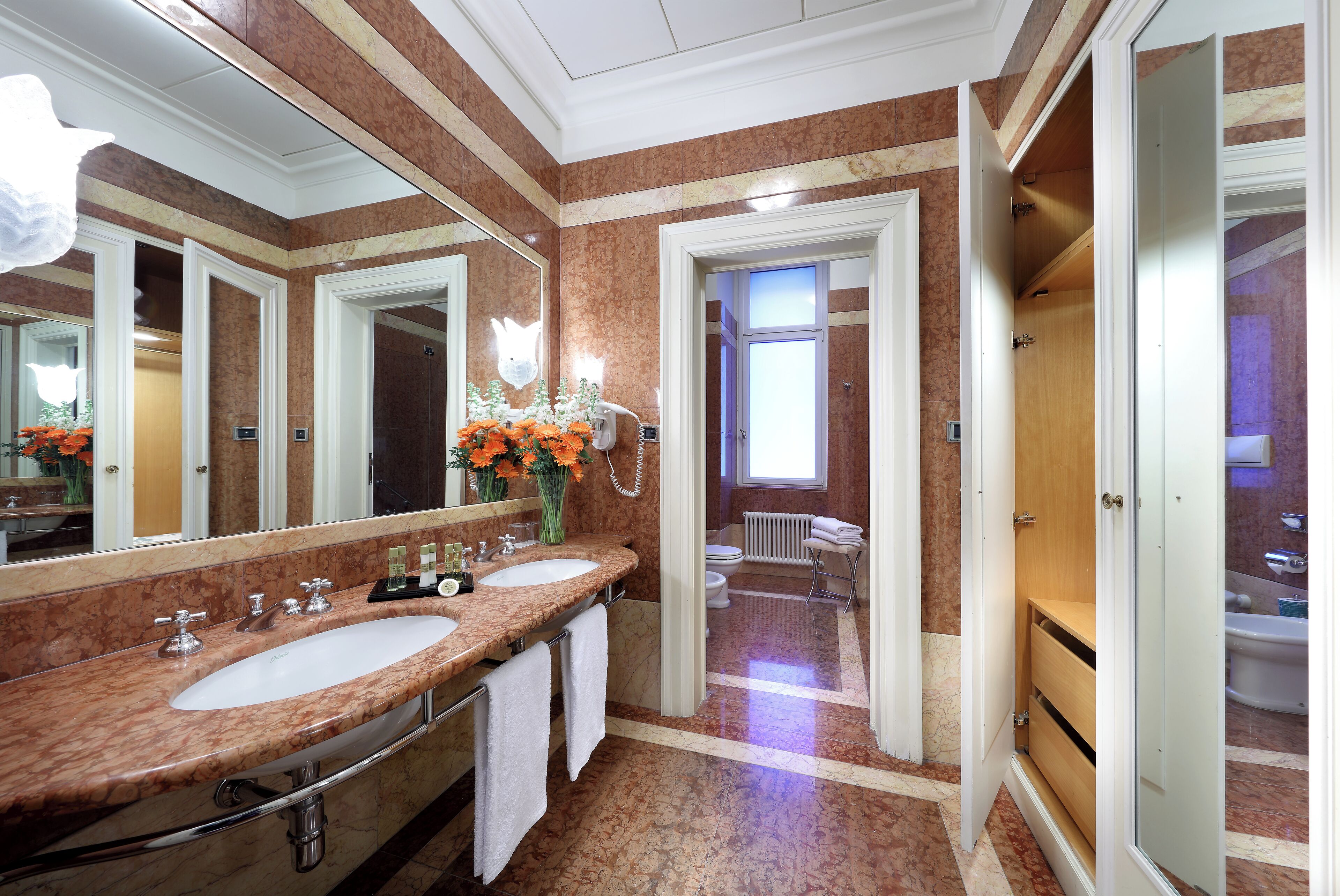 A bathroom with two sinks, a large mirror, and a shower area.