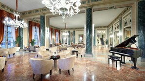 A spacious lobby with a grand piano, elegant chandeliers, and comfortable seating areas. - Eurostars Hotel Excelsior (Naples)