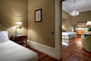 Una camera d'albergo con un letto, un comodino, una lampada e un quadro appeso al muro.