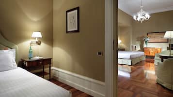 A hotel room with a bed, bedside table, lamp, and a framed picture on the wall.