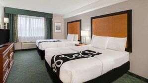 A hotel room with two beds, a dresser, a television, and a window with curtains. - La Quinta Inn by Wyndham Everett (Everett)