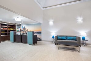 A hotel lobby with a reception desk, a sofa, and a wall mural. - La Quinta Inn by Wyndham Everett (Everett)