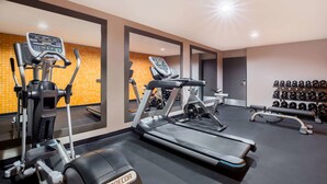 A gym with treadmills, an elliptical, and a bench press. There are weights and a mirror on the wall. - La Quinta Inn by Wyndham Everett (Everett)