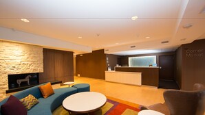A modern lobby with a stone wall, a reception desk, and seating areas. - Fairfield Inn & Suites by Marriott Burlington (Burlington)