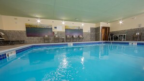 An indoor swimming pool with clear water, tiled walls, and several lounge chairs along the side. - Fairfield Inn & Suites by Marriott Burlington (Burlington)