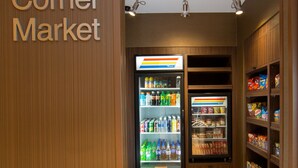 A corner market with refrigerated beverage dispensers and shelves stocked with snacks. - Fairfield Inn & Suites by Marriott Burlington (Burlington)