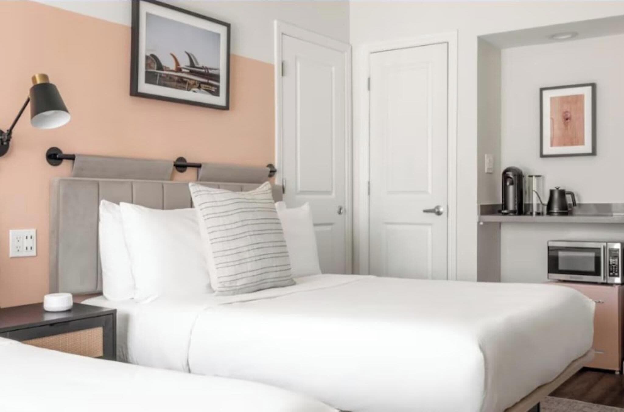 Une chambre d’hôtel équipée d’un lit, d’une lampe de chevet et d’une kitchenette avec un four à micro-ondes.