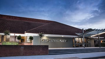 A building with a tiled roof and a sign that reads 'CROWNE PLAZA'.