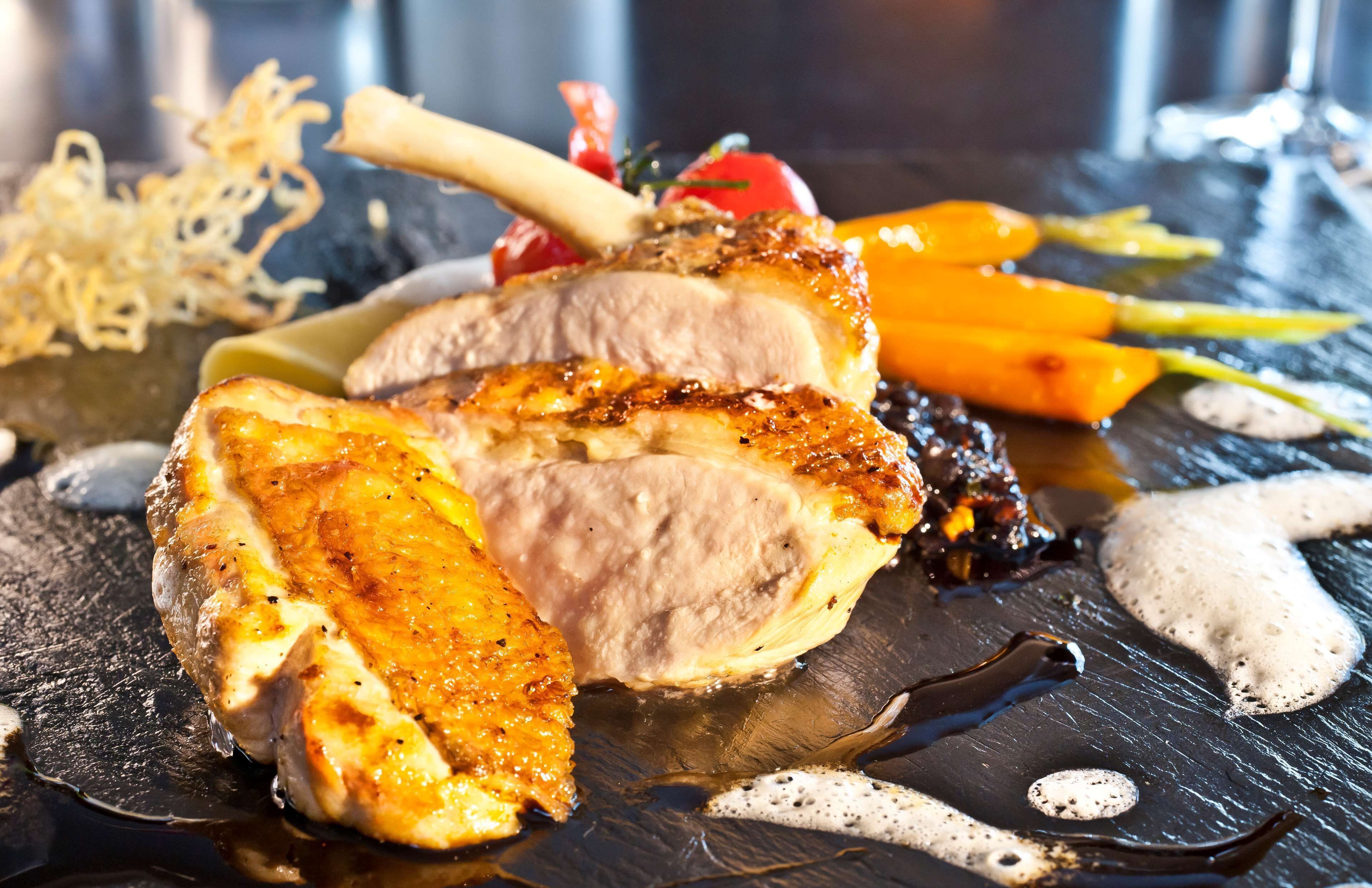 Ein Teller mit geschnittenem Fleisch, Gemüse und Soße.