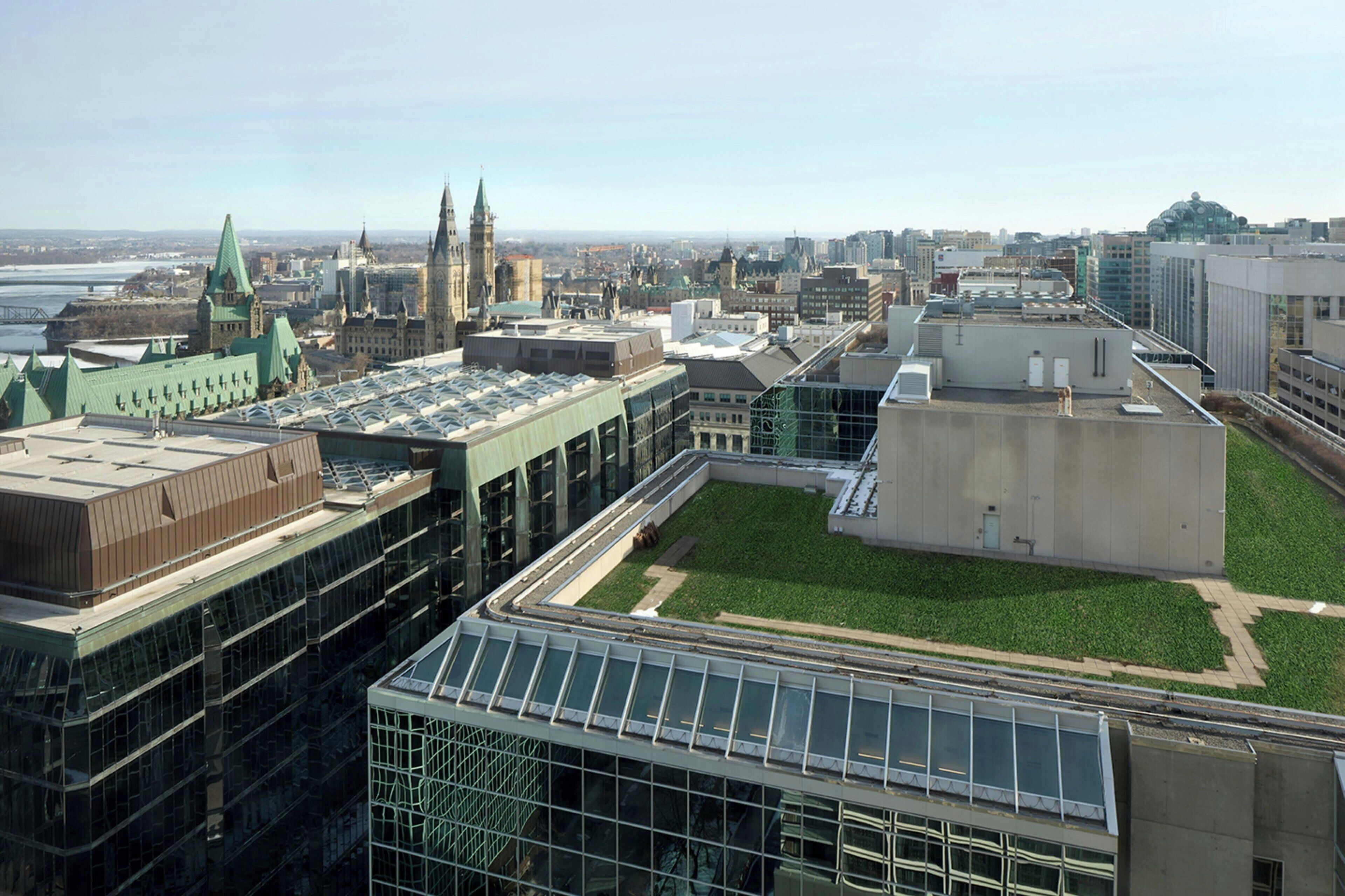 A high-rise building with a rooftop garden, large windows, and a mix of modern and traditional architecture.