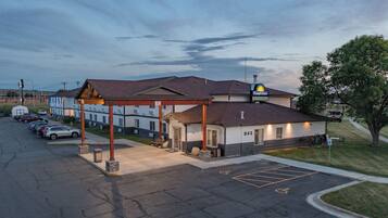 A motel with a covered parking area, a visible handicap parking symbol, and a number '843' on the building.