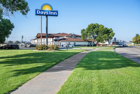 Un Days Inn con un letrero grande, un estacionamiento y un césped bien cuidado.