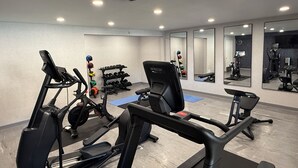 A gym with treadmills, weight machines, and free weights.