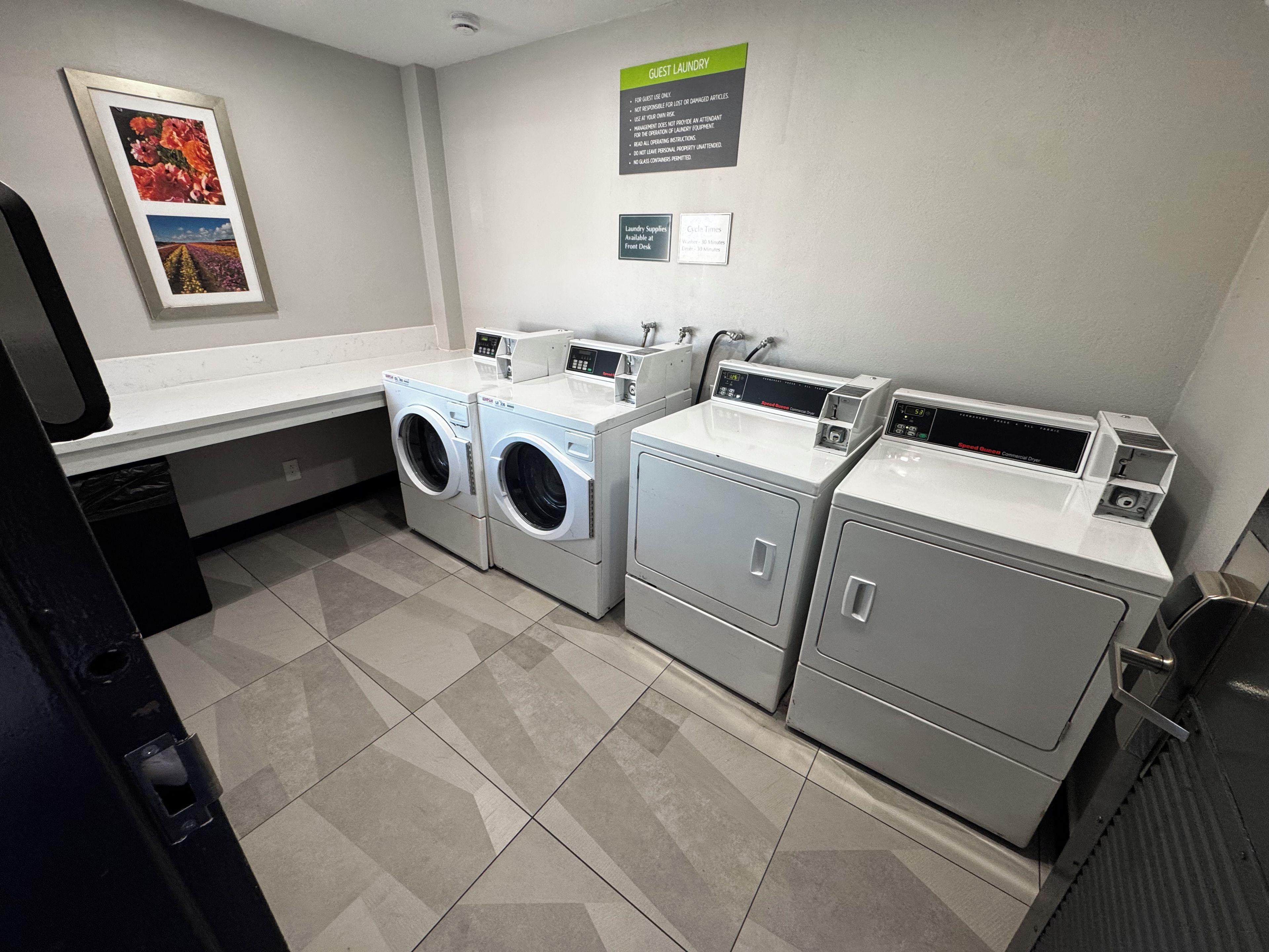 A laundry area with a washing machine, dryer, and ironing station.