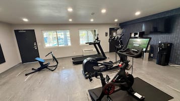 A gym with treadmills, an elliptical, and a stationary bike.