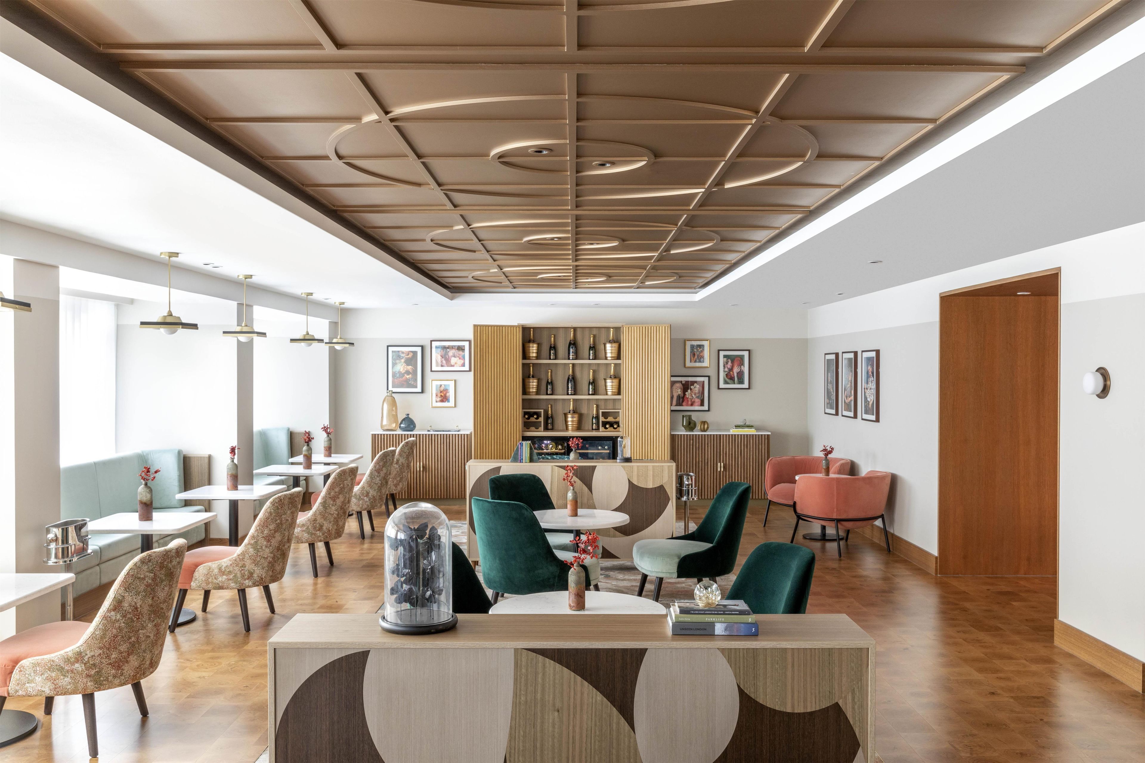Un intérieur moderne avec un bar central, des espaces de détente et une bibliothèque.
