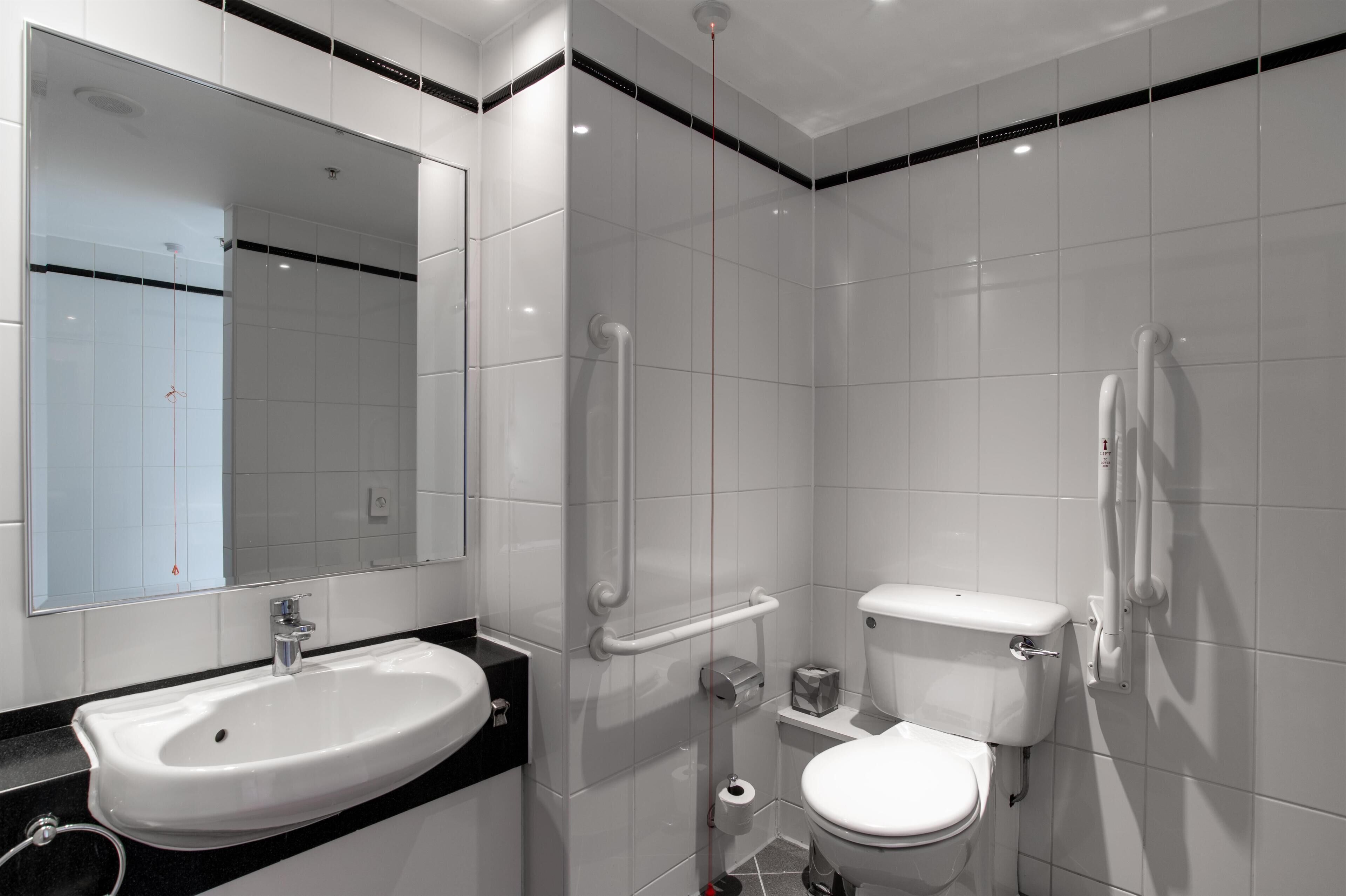 A modern bathroom with a sink, toilet, and shower.
