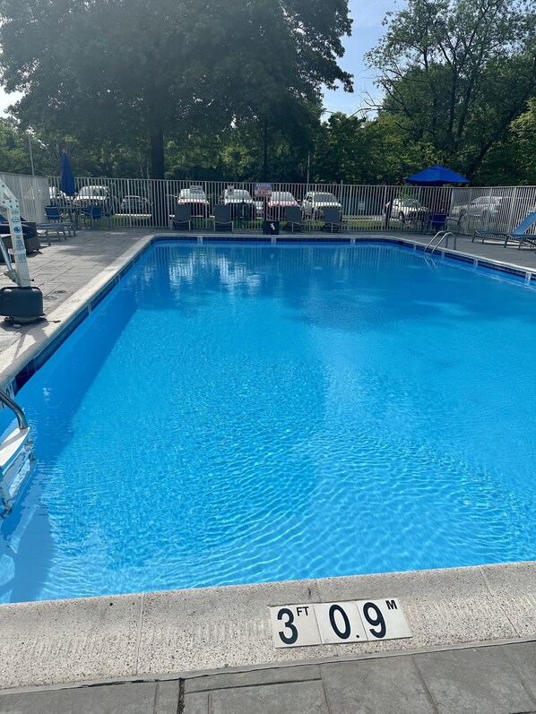 Piscine extérieure en saison, chaises longues