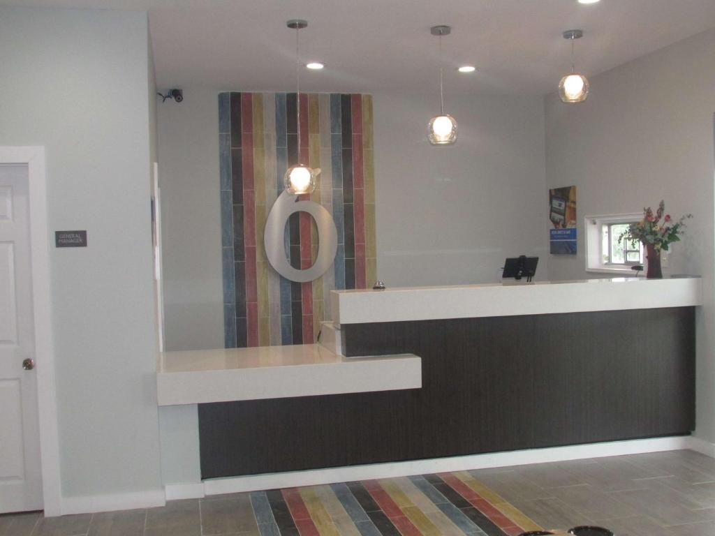 A reception area with a modern design, featuring a reception desk, a colorful striped wall, and pendant lighting.