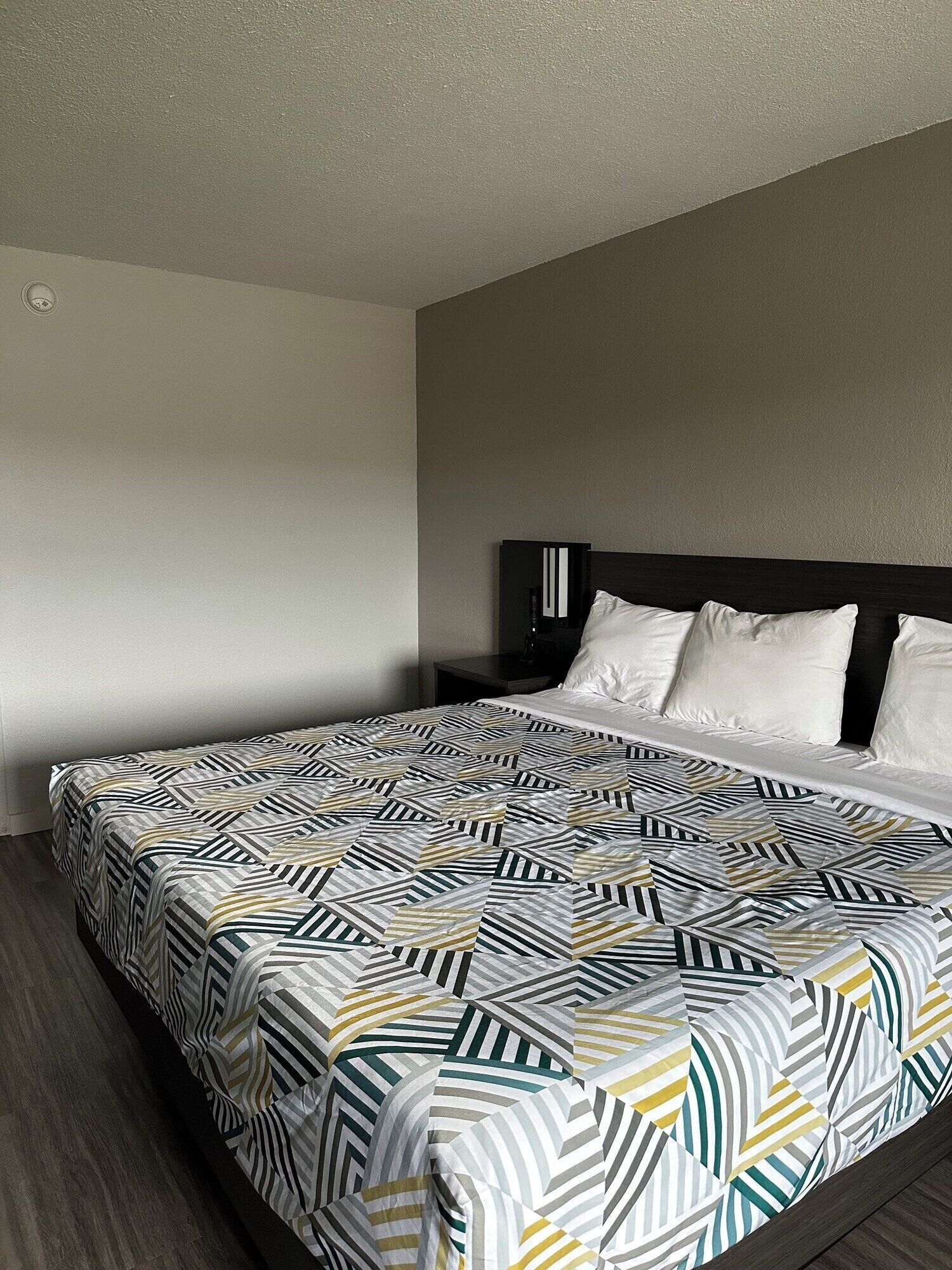 Ein Hotelzimmer mit einem Bett, einem Nachttisch und einer Steckdose.