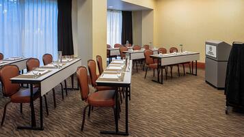 Une salle de conférence équipée de longues tables, de chaises et d’un pupitre.