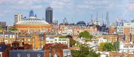 A cityscape with a mix of historic and modern buildings, including a prominent dome structure and the London Eye.