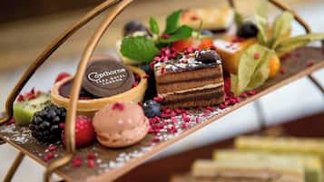 Una bandeja de postres con diversos dulces y un cartel que dice 'Cophorne Tara Hotel London'.