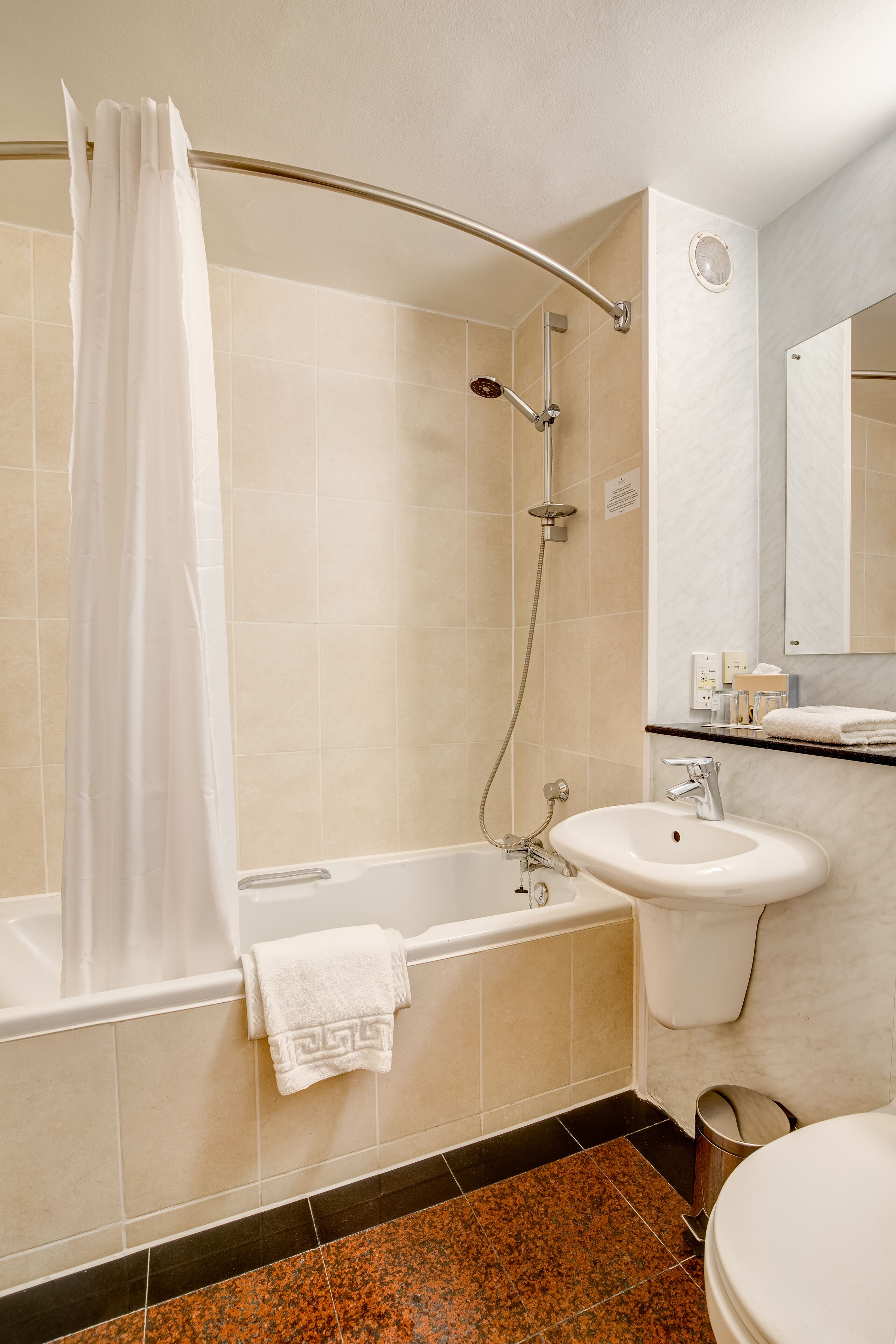 A bathroom with a bathtub, shower, sink, and toilet.