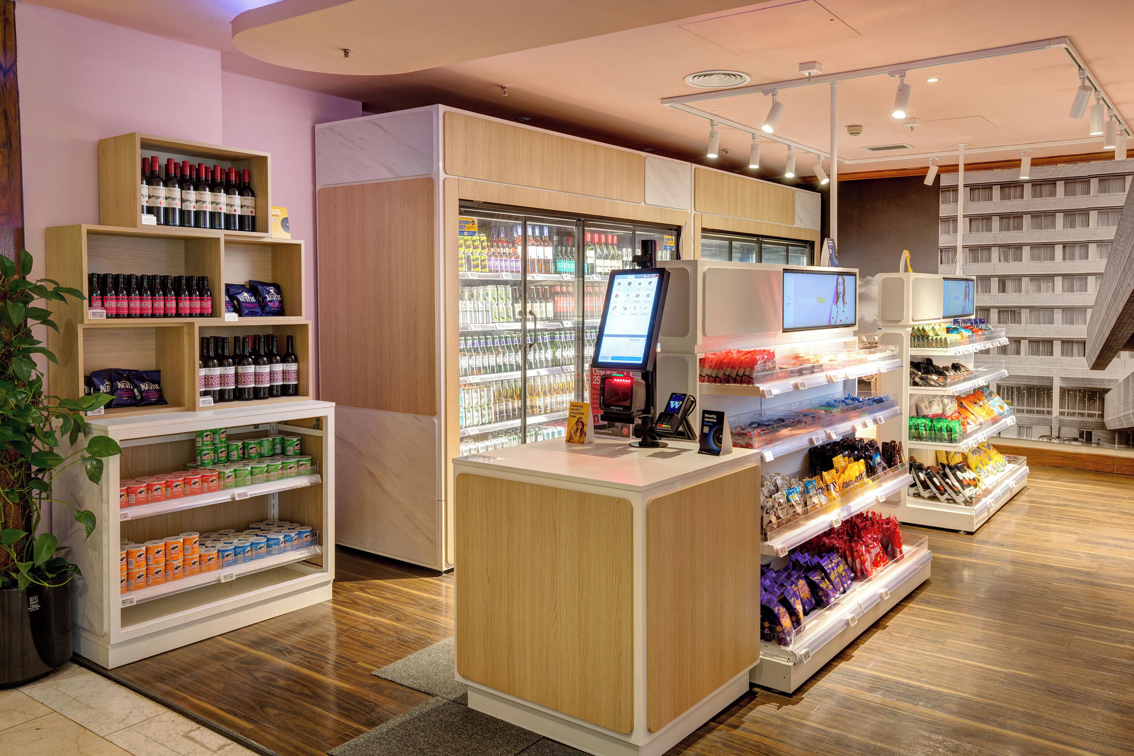 Een moderne winkel met houten planken, koelvitrines en een kassa.