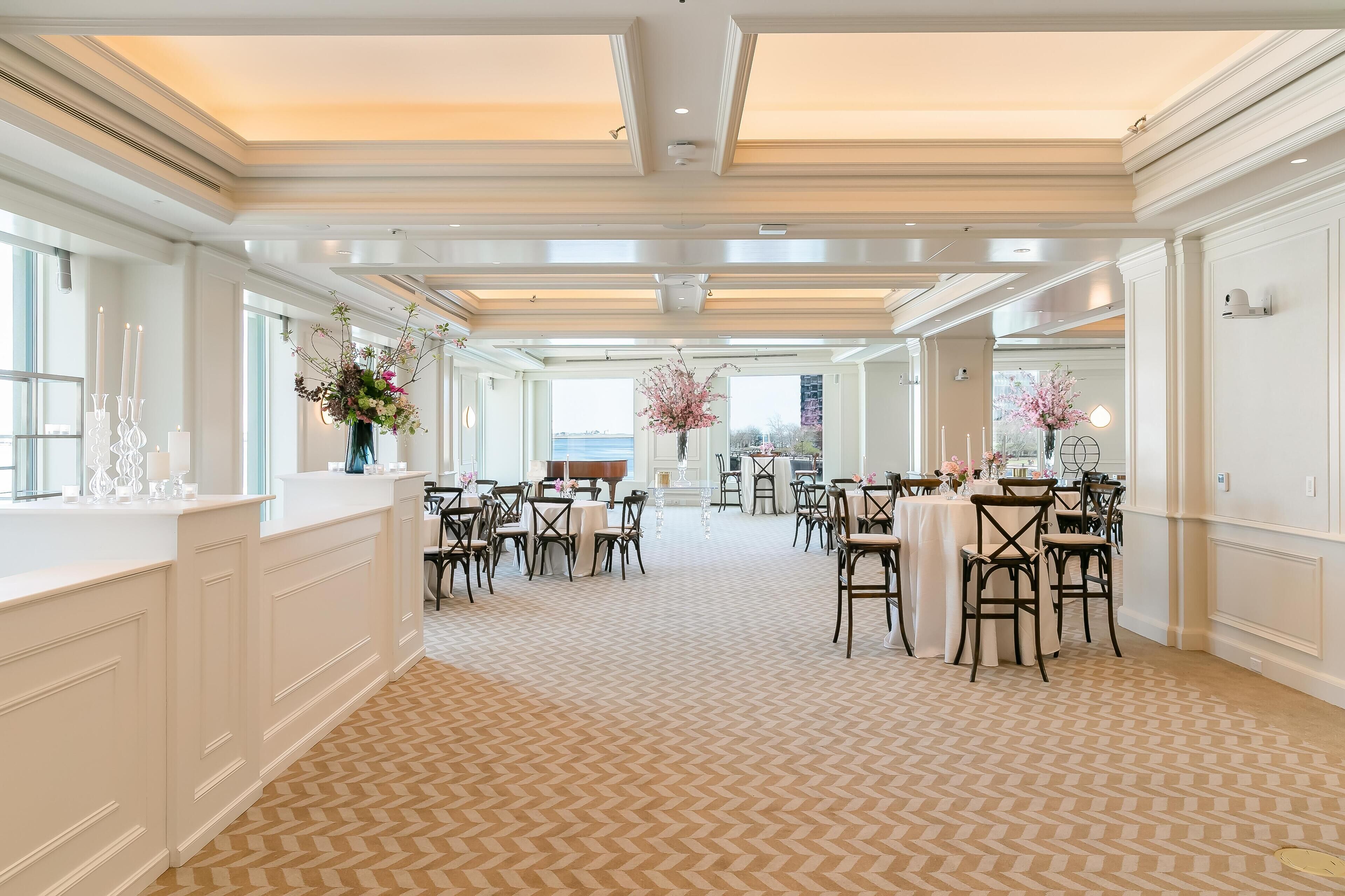 Een ruime hotellobby met een kamerbreed tapijt, witte muren en kroonluchters.