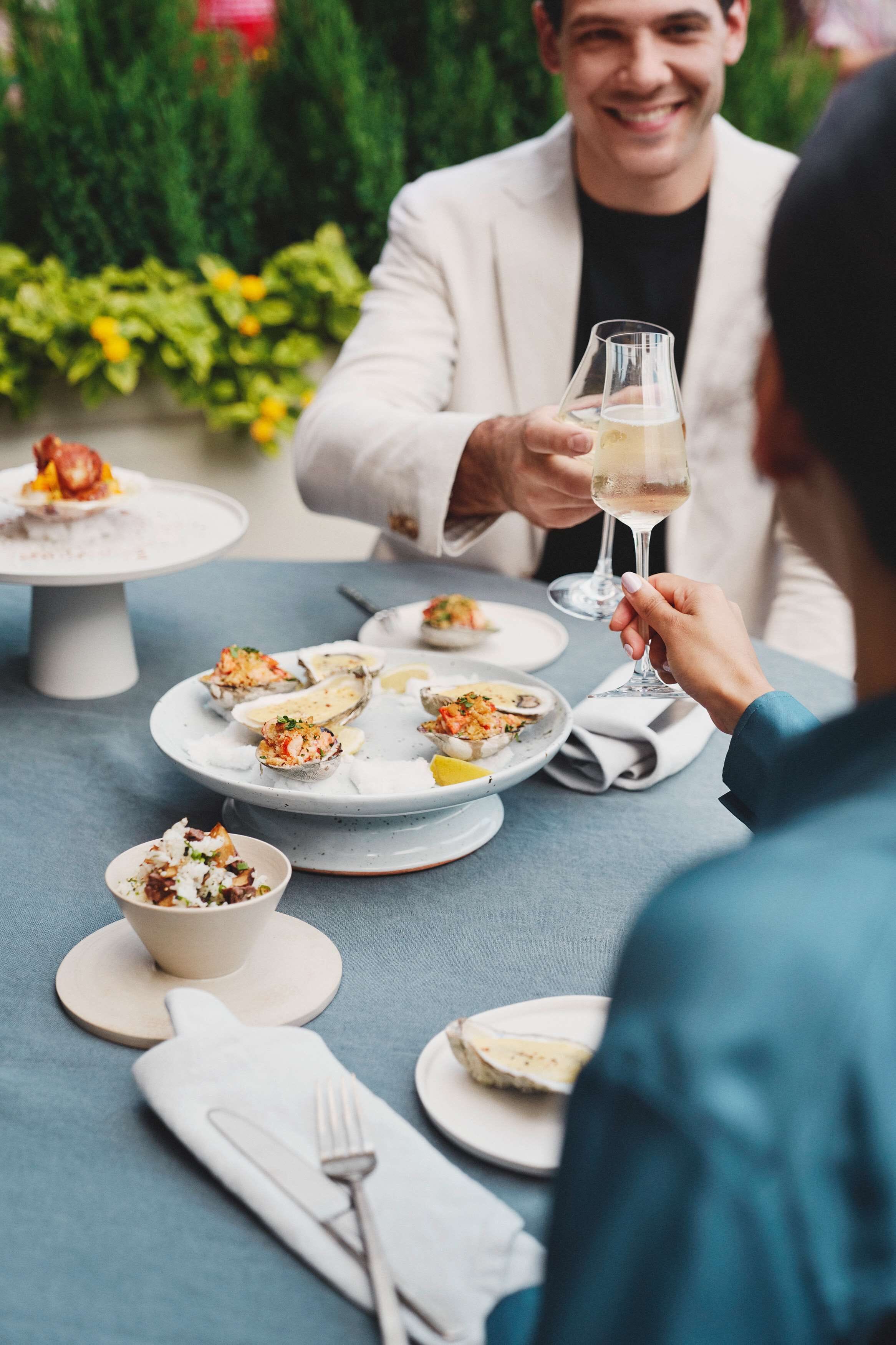 Une table à manger avec des assiettes remplies de nourriture et un verre de vin.