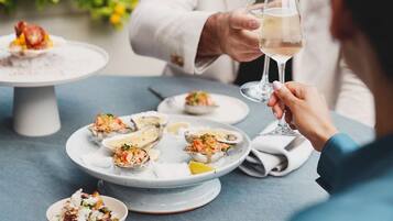 Une table à manger avec des assiettes remplies de nourriture et un verre de vin.