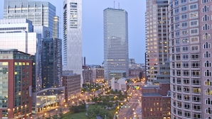 Un paisaje urbano con modernos edificios altos, una glorieta central y una combinación de estructuras comerciales y residenciales.