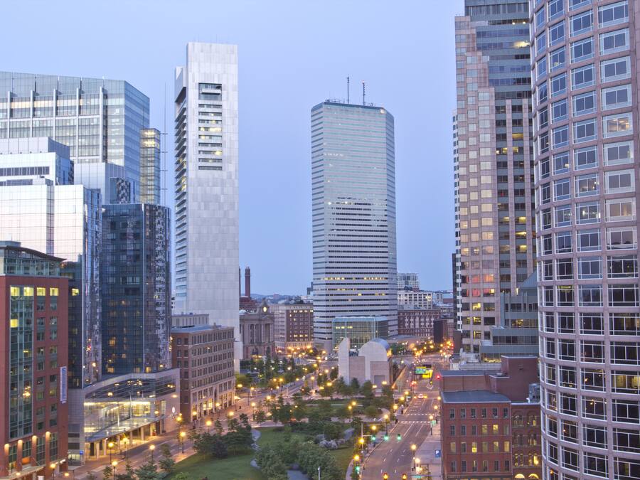 A cityscape with modern high-rise buildings, a central roundabout, and a mix of commercial and residential structures.