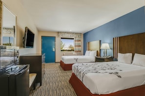 A hotel room with two beds, a desk, a TV, and a view of the outdoors. - Econo Lodge Inn & Suites Enid South (Enid)