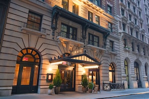 L’hôtel Evelyn se distingue par sa façade classique, ses grandes fenêtres et son entrée imposante.