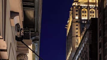 El letrero del Hotel Evelyn, con un diseño arquitectónico clásico, en un paisaje urbano nocturno.