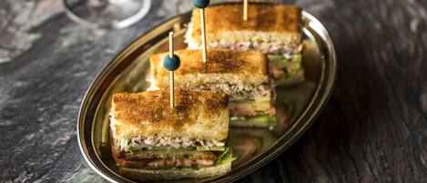 Un plato con tres sándwiches tostados, cada uno con un palillo.