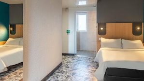 A hotel room with two beds, a large window, a door, and a ceiling vent.