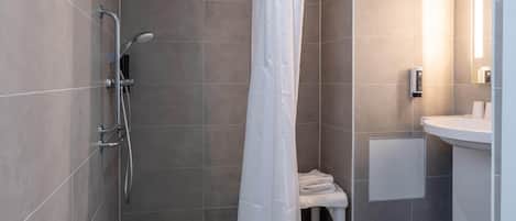 A modern bathroom with a shower, a toilet, and a sink.