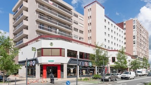 A multi-story hotel with balconies, a ground-level restaurant, and a visible storefront.
