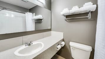 Un bagno moderno con lavandino, specchio, porta asciugamani e water.