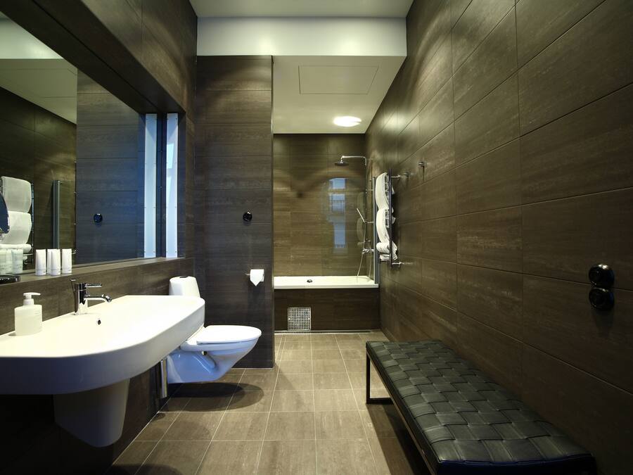 Un bagno moderno con un lavandino capiente, il water e una vasca da bagno.