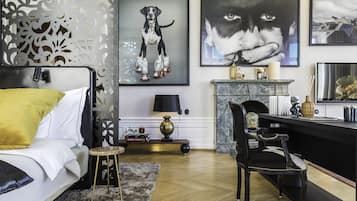 Una sala moderna con un sofá, un taburete pequeño, una chimenea y un escritorio con una silla.