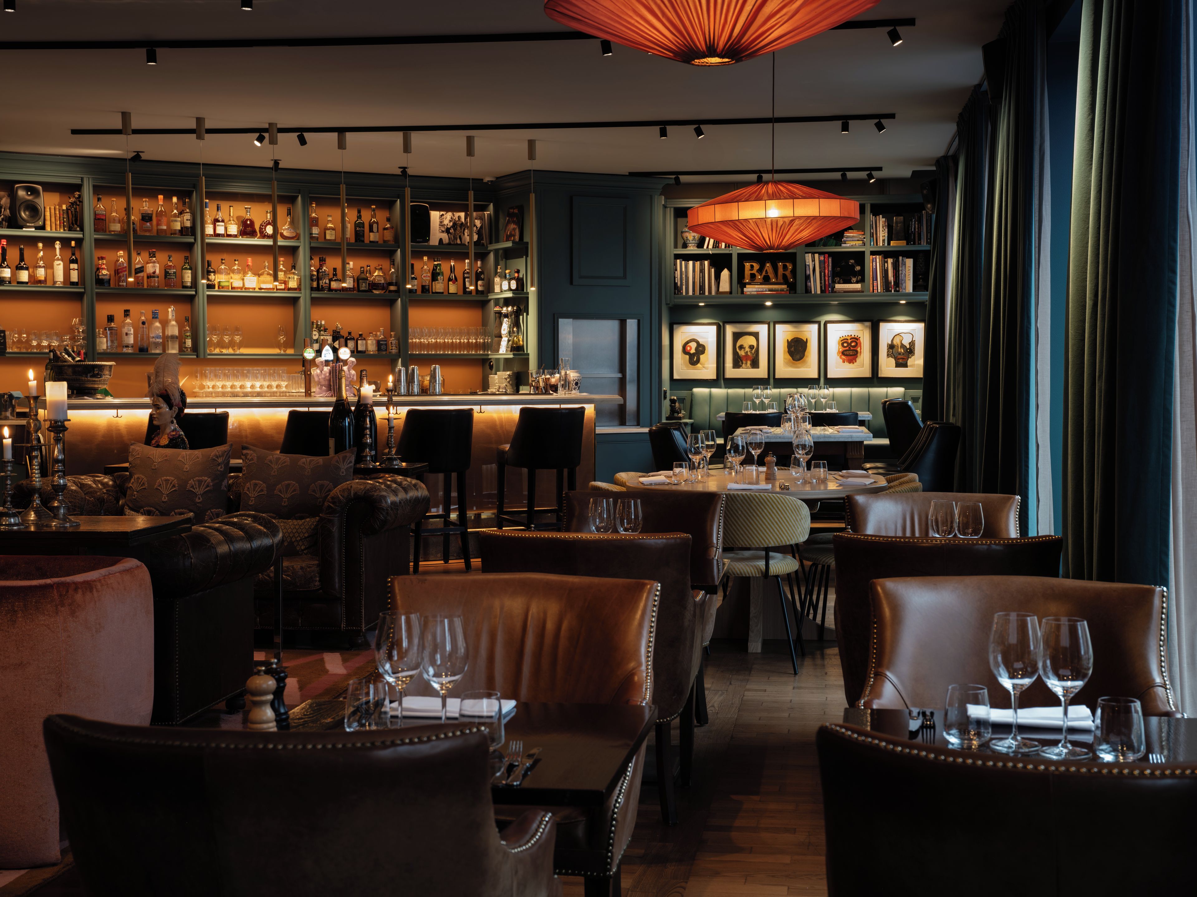 Eine Bar mit Regalen voller Flaschen, einer Theke und Sitzgelegenheiten.