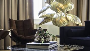 Una sala de estar moderna con una mesa de centro redonda, un sofá y una gran planta en maceta.